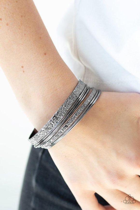 Paparazzi Full Circle - Black  -  Brushed in a high-sheen shimmer, a collection of smooth and heavily hammered gunmetal bangles slides up and down the wrist for an edgy stacked look.
