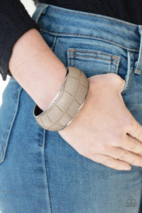Paparazzi Urban Jungle - Silver  -  Featuring a subtle crocodile print, a faux piece of gray leather wraps around a dramatically oversized silver bangle for a bold look.
