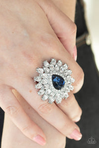 Paparazzi Whos Counting? - Blue - Ring  -  White teardrop petals fan out from a dramatic blue teardrop rhinestone center, stacking into a glamorous centerpiece atop the finger. Features a stretchy band for a flexible fit.
