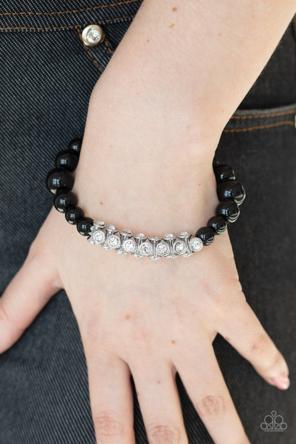 Paparazzi Traffic-Stopping Sparkle - Black - Bracelet  -  A collection of black beads and white rhinestone dotted silver frames are threaded along a stretchy band around the wrist, creating a sparkling centerpiece.

