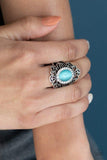 Paparazzi Dashingly Dewy - Blue  -  Ringed in glassy white rhinestones, a dewy blue cat's eye stone is pressed into the center of a frilly silver frame swirling with studded filigree. Features a stretchy band for a flexible fit.
