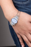 Paparazzi Brilliantly Boho - Blue - Bracelet  -  Dotted with opaque blue and white beads, white rhinestone encrusted silver frames flare out from a dewy blue beaded center. Two dainty silver chains attach to the colorful centerpiece for a whimsically layered look. Features an adjustable clasp closure.
