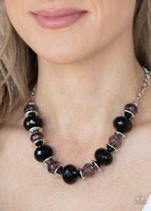 Paparazzi Hollywood Gossip - Black - Necklace  -  Saucer shaped silver beads trickle between faceted black beads and smoky crystal-like beads along an invisible wire, creating a glamorous display below the collar. Features an adjustable clasp closure.
