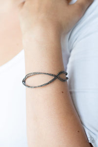 Paparazzi Bending Over Backwards - Black - Bracelet  -  Featuring diamond-cut texture, dainty gunmetal bars delicately crisscross over and around the wrist, coalescing into an airy cuff.

