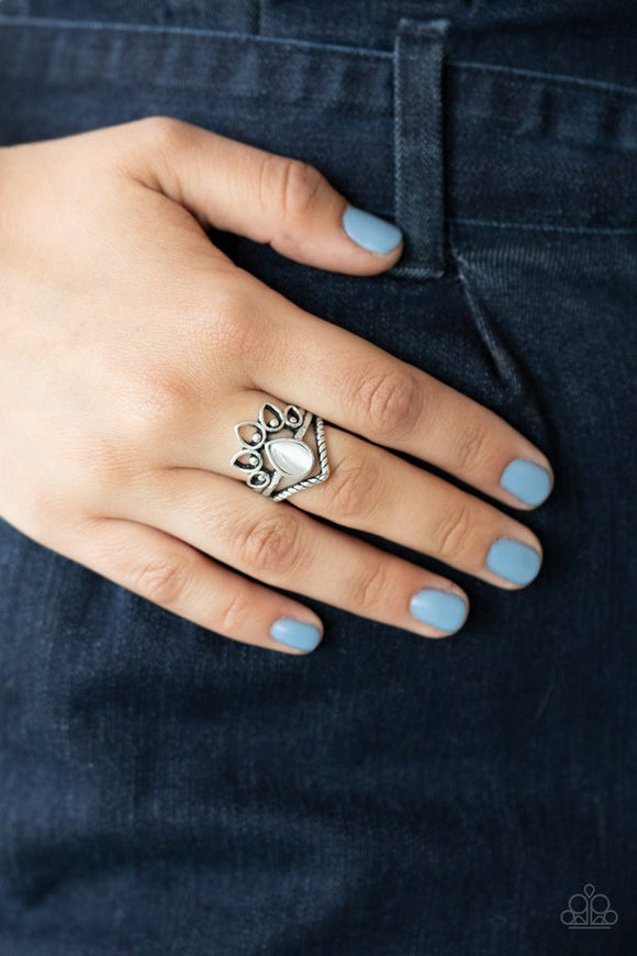 Paparazzi Serene Scene - White - Ring  -  Dotting the center of a dainty silver band, a milky white cat's eye stone teardrop is flanked between an angled rope-like band and an airy fan of studded silver petals. Features a dainty stretchy band for a flexible fit.
