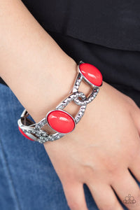 Paparazzi Dreamy Gleam - Red - Bracelet  -  Oversized red beads and interwoven silver frames are threaded along stretchy bands around the wrist. The silver frames are dotted in antiqued studs, adding tactile texture to the colorful piece.
