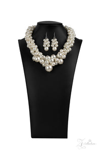 Paparazzi Regal - 2020 Zi Signature Collection  -  An exaggerated display of clustered pearls elegantly sweeps below the collar. The classic white pearls gradually increase in bubbly intensity as they reach the center of the regal piece, adding over-the-top timelessness to the unapologetic pearl palette. Features an adjustable clasp closure.
