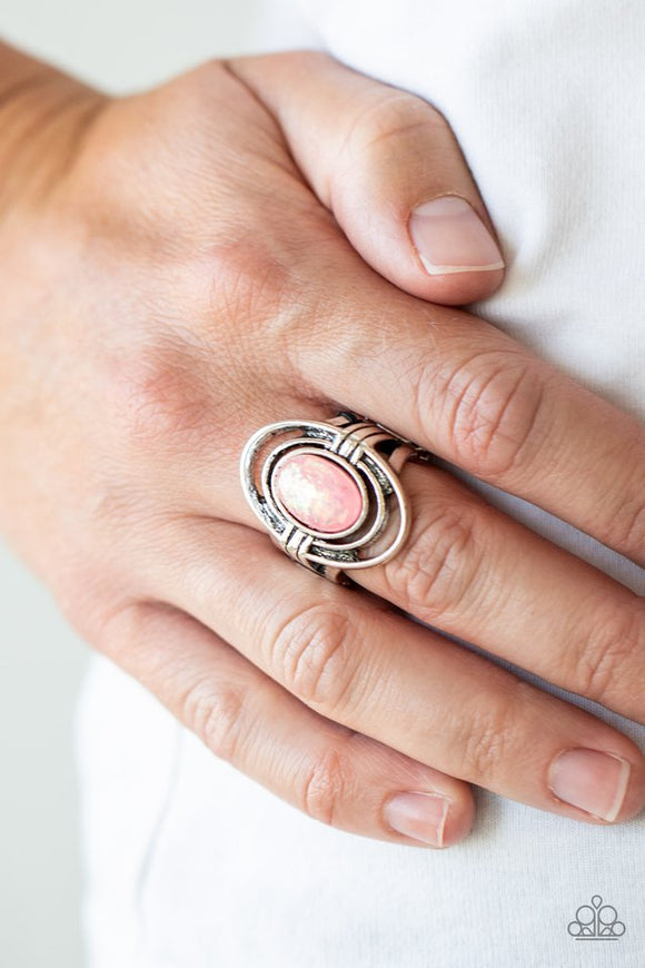 Paparazzi Peacefully Pristine - Pink - Ring  -  A sparkly pink opalescent bead is nestled between rippling silver ovals, creating an ethereal frame atop the finger. Features a stretchy band for a flexible fit.
