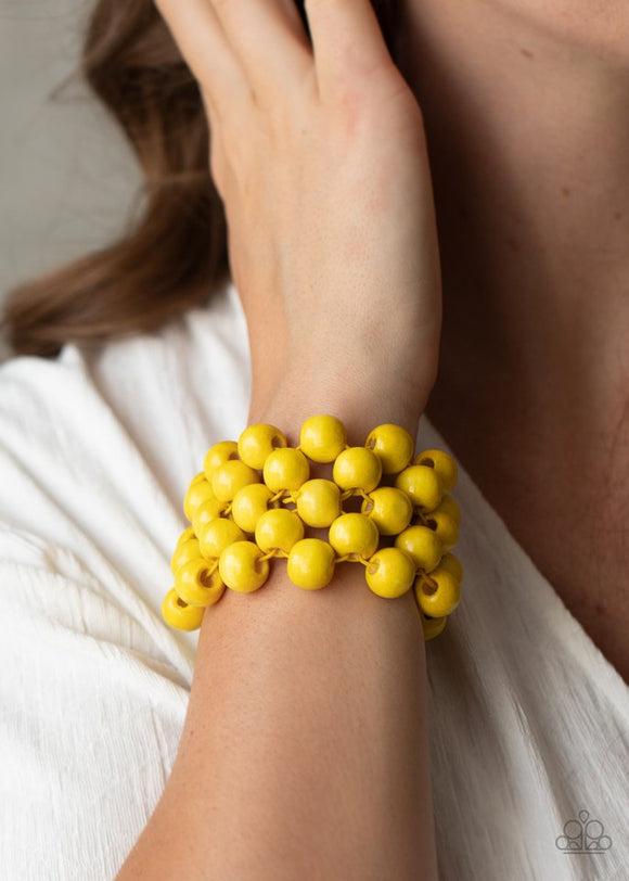 Paparazzi Tiki Tropicana - Yellow - Bracelet  -  An oversized collection of sunny yellow wooden beads are threaded along stretchy bands that ornately weave across the wrist, creating a decorative summery pattern.
