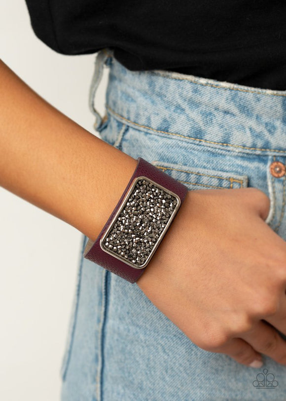Paparazzi Interstellar Shimmer - Purple - Bracelet  -  A collision of smoky and hematite rhinestones collect inside a silver rectangular frame that is studded in place in the center of a thick plum leather band, creating a sparkling statement piece around the wrist. Features an adjustable snap closure.
