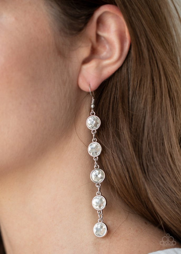 Paparazzi Trickle Down Twinkle - White - Earrings
Encased in sleek silver fittings, a dramatic row of oversized white rhinestones delicately link in an elongated lure for a glamorous look. Earring attaches to a standard fishhook fitting.
