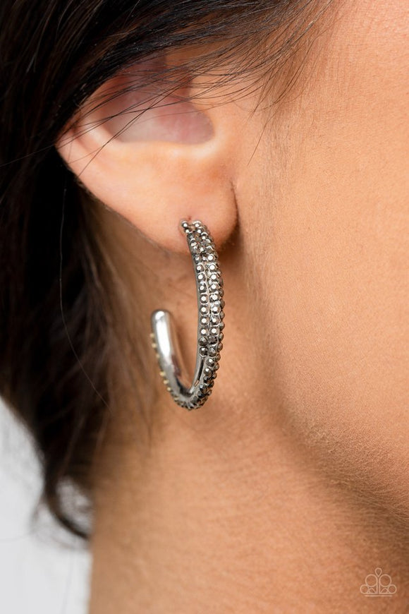 Paparazzi Trail Of Twinkle - Silver - Earrings  -  Two dainty rows of glittery hematite rhinestone encrusted silver bars delicately overlap and twist into a hook shaped hoop for a refined flair. Earring attaches to a standard post fitting. Hoop measures approximately 1