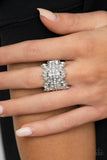 Paparazzi Cosmic Confetti - White - Ring  -  A row of small white gems gives way to an eruption of glassy mismatched round and marquise-cut white rhinestones that wraps dramatically around the finger. Metallic studs sprinkled throughout the design add depth and extra edgy refinement. Features a stretchy band for a flexible fit.
