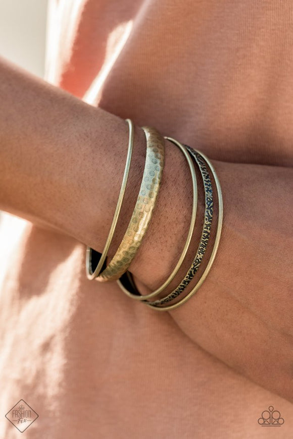 Paparazzi Get Into Gear - Brass - Bracelet  - January 2021 Fashion Fix Exclusive  -  A mismatched collection of smooth, hammered, and textured brass bangles stack up the wrist for an edgy, industrial effect.
