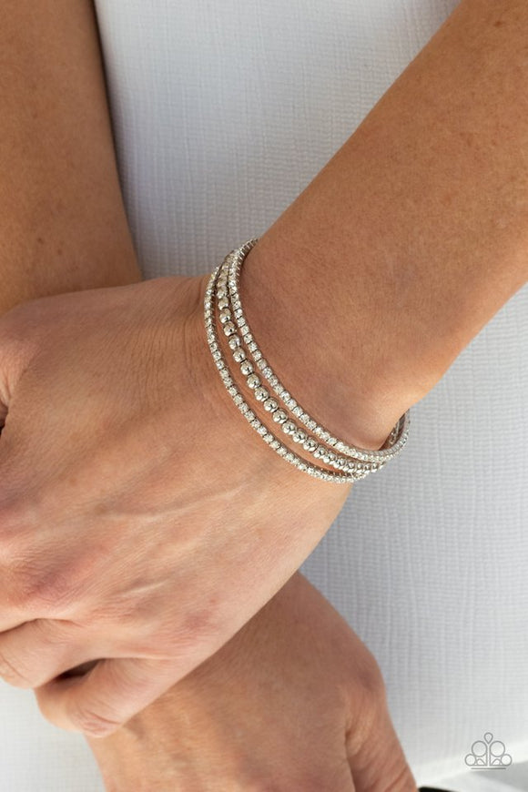 Paparazzi High-End Eye Candy - White - Bracelet  -  Two strands of dazzling white rhinestones flank a row of shiny silver beads, coalescing into a sparkly layered cuff around the wrist.
