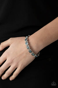 Paparazzi Cosmic Conquest - Blue - Bracelet  -  Dotted with iridescent blue rhinestone centers, studded silver frames alternate with pairs of dainty silver beads along stretchy bands, creating a stellar centerpiece around the wrist.
