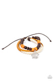 Paparazzi Lotus Beach - Orange - Bracelet  -  Featuring a silver lotus charm, a strand of brown and orange wooden beads, braided white cording, and strands of brown leather layer around the wrist for a seasonal flair. Features an adjustable sliding knot closure.
