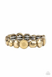 Paparazzi Extra Exposure - Brass - Bracelet  -  Encased in sleek brass frames, a smoldering collection of round and emerald cut aurum rhinestones glide along stretchy bands around the wrist, creating a sparkly industrial statement piece.
