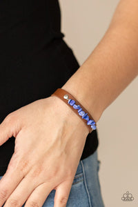 Paparazzi Pebble Paradise - Blue - Bracelet  -  A strand of blue pebbles is studded in place across the front of a skinny brown leather band, creating a colorful earthy display around the wrist. Features an adjustable snap closure.
