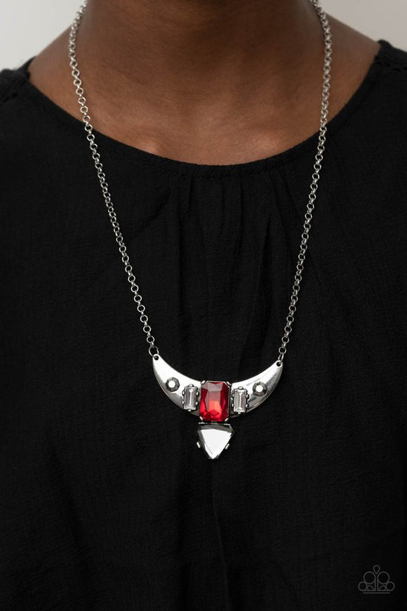 Paparazzi You the TALISMAN! - Red - Necklace  -  Pairs of faceted silver beads and glassy white emerald cut gems flank an oversized emerald cut red gem atop an antiqued silver half moon frame. A smoky triangular cut gem adorns the bottom of the pendant, creating a twinkly talisman at the bottom of a classic silver chain. Features an adjustable clasp closure.
