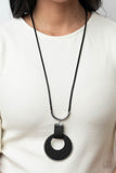 Paparazzi Luxe Crush - Black - Necklace  -  A large cutout silver disc, overlaid with black leather, is cradled in a wide black leather strap. The luxe pendant sways from a U-shaped silver cylinder threaded along the end of a lengthened polished black cord for an indulgently lavish finish. Features a sliding bead closure.
