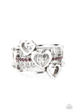 Paparazzi Give Me AMOR - Purple - Ring  -  Infused with a row of glittery purple rhinestones, a trio of airy silver hearts slant across three silver bands that layer into a charming centerpiece atop the finger. Features a stretchy band for a flexible fit. 
