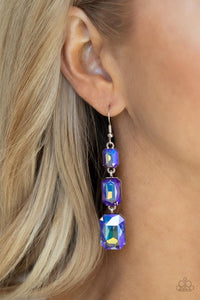 Paparazzi Cosmic Red Carpet - Blue - Earrings  -  Featuring a dazzling blue and gold UV shimmer, a trio of emerald-cut gems in graduating sizes is linked one below the other for a dramatic red carpet finish. Earring attaches to a standard fishhook fitting.
