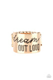 Paparazzi Dream Louder - Gold - Ring  -  The front of a thick gold band is stamped in the phrase, "Dream out loud," creating an inspirational centerpiece across the finger. Features a stretchy band for a flexible fit.
