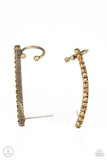 Paparazzi Give Me The SWOOP - Brass Post Earring - Earrings  -  A dainty row of glitzy aurum rhinestones is encrusted along a gritty brass bar that swoops up the ear for a smoldering style. Features a dainty cuff attached to the top for a secure fit.
