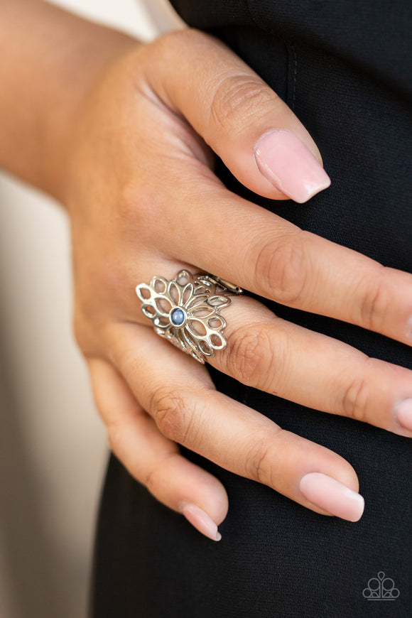 Paparazzi Perennial Daydream - Blue - Ring  - 2021 Convention Exclusive  -  A smattering of airy silver petals blooms from a tranquil Spring Lake bead, creating an enchanting floral centerpiece atop the finger. Features a stretchy band for a flexible fit.
