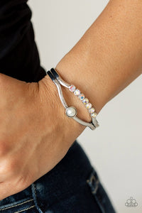 Paparazzi Palace Prize - Multi - Bracelet  -  A row of iridescent rhinestones and a solitaire white pearl adorn the layered center of a classic silver cuff, creating a timeless piece around the wrist.
