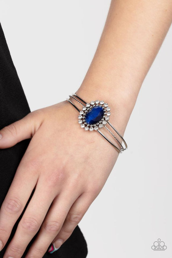 Paparazzi Prismatic Flower Patch - Blue - Bracelet  -  Bordered in glitzy rings of glittery white rhinestones and shiny silver studs, a faceted Rhodonite gem adorns the center of an ornately layered silver cuff for a flowery fashion.
