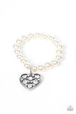Paparazzi Cutely Crushing - White - Bracelet  -  A dramatically oversized white rhinestone encrusted silver heart charm dangles from a stretchy strand of bubbly white pearls, creating a flirtatious dazzle.
