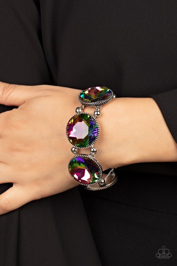 Paparazzi Powerhouse Hustle - Multi - Bracelet  -  Infused with pairs of silver beads, a glitzy collection of dramatically oversized oil spill rhinestone frames are threaded along stretchy bands around the wrist for a jaw-dropping dazzle.
