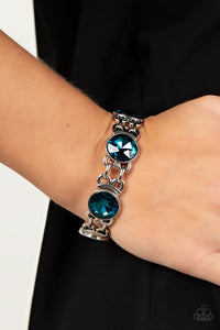 Paparazzi Devoted to Drama - Blue - Bracelet  -  Featuring edgy chain-like fittings, a sparkly series of oversized blue rhinestones are threaded along stretchy bands around the wrist for a dramatic pop of glitz.
