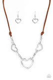 Paparazzi Fashionable Flirt - Brown - Set  -  Strands of brown suede knot around sections of chunky silver chains that have been adorned in oversized silver heart frames, resulting in a flirtatious display below the collar. Features an adjustable clasp closure.