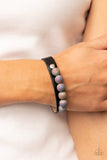 Paparazzi Saturn Safari - Black - Bracelet  -  Brushed in shimmering glitter, multicolored beads are infused with swirls of blue, green, purple, and yellow. Threaded along a wire, the colorful collection is layered atop a black leather band for an out-of-this-world finish. Features an adjustable snap closure.
