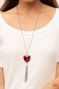 Paparazzi Finding My Forever - Red - Necklace  -  Bordered in a ribbon of glassy white rhinestones, an oversized red heart-shaped gem seemingly floats at the bottom of an extended silver chain. A shimmery silver chain tassel dances from the bottom of the sparkly pendant for a flirtatious finish. Features an adjustable clasp closure.
