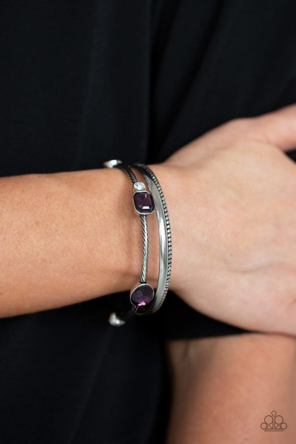 Paparazzi City Slicker Sleek - Purple  -  Brushed in an antiqued shimmer, a collection of smooth and textured silver bangles stack across the wrist. Varying in shape and size, glittery purple and white rhinestones are encrusted along one bangle for a glamorous glow.
