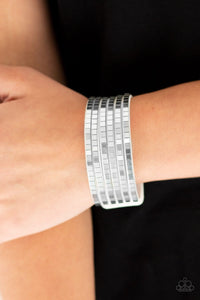 Paparazzi Disco Dazzle - White
Flat silver cubes are encrusted along strips of white suede, creating a blinding shimmer around the wrist. Features an adjustable snap closure.