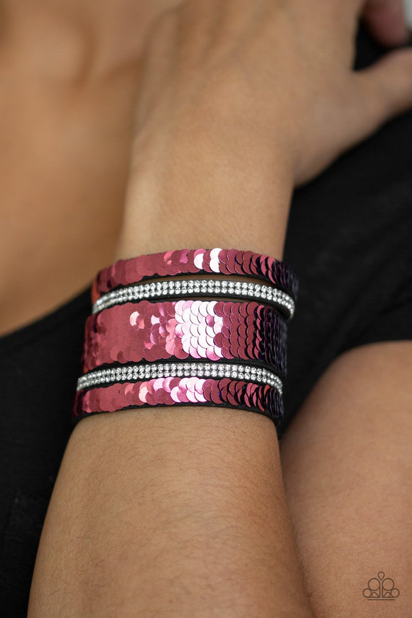 Paparazzi MERMAID Service - Pink
Infused with strands of blinding white rhinestones, row after row of shimmery sequins are stitched across the front of a spliced black suede band. Bracelet features reversible sequins that change from blue to pink. Features an adjustable snap closure.
