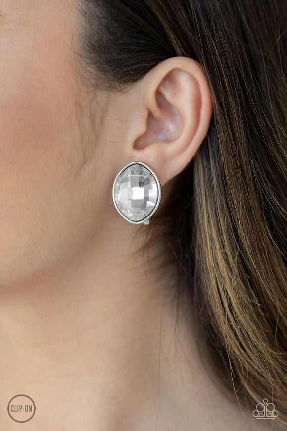 Paparazzi Movie Star Sparkle - White
Featuring a faceted finish, an oversized marquise-shaped gem is nestled in a sleek silver frame for an undeniably statement-making look. Earring attaches to a standard clip-on fitting.
