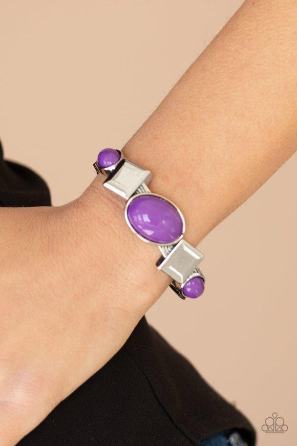 Paparazzi Abstract Appeal - Purple - Bracelet
Vivacious purple oval beads and antiqued silver square frames are pressed into the textured front of a cuff-like bangle, creating a colorful pop of color around the wrist. Features a hinged closure. 