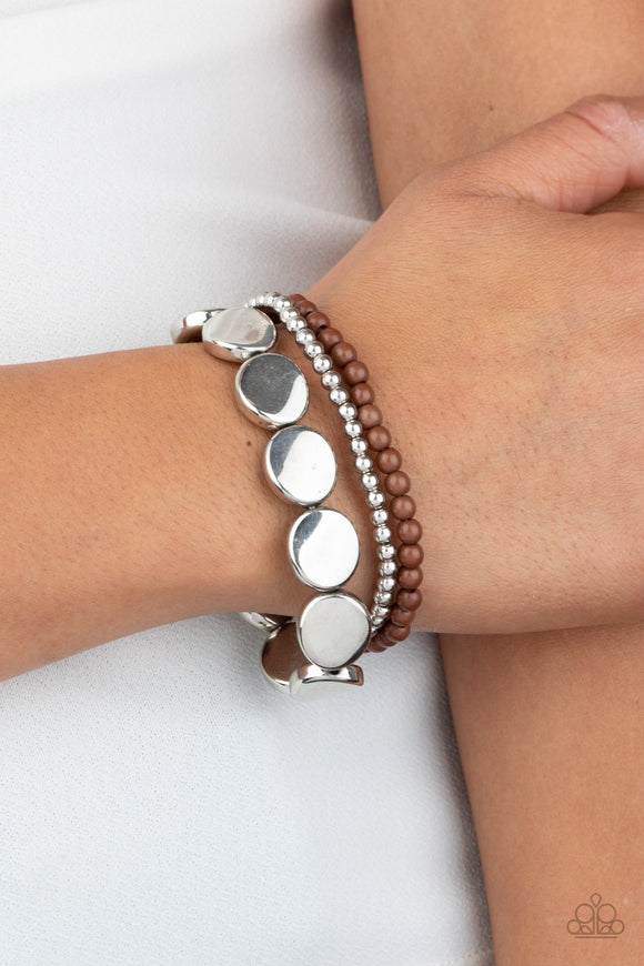 Paparazzi Beyond The Basics - Brown - Bracelet
Mismatched silver and brown beads and round silver accents are threaded along stretchy bands, creating colorful layers around the wrist.
