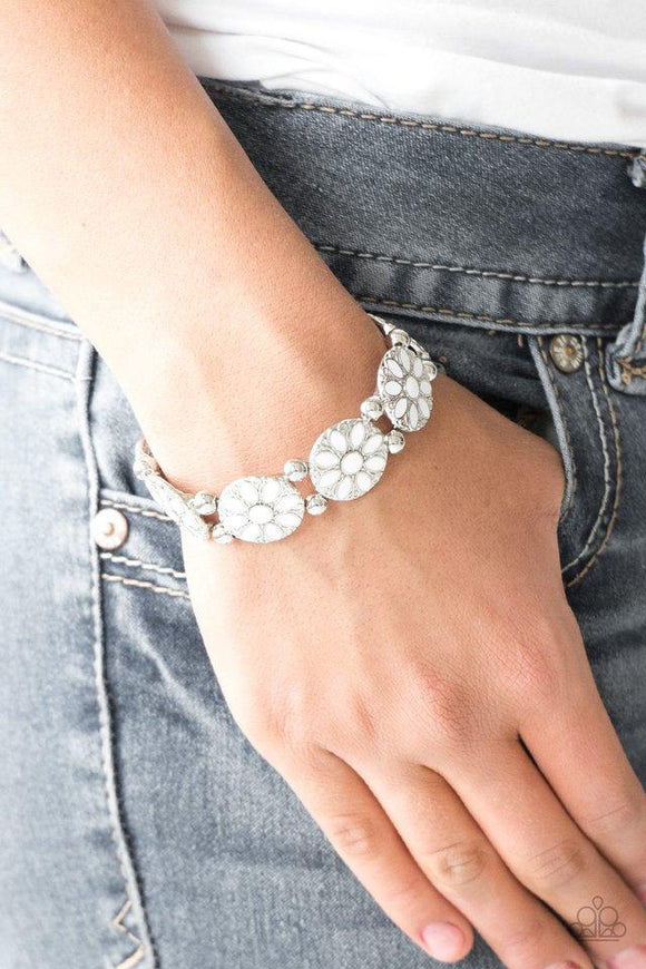 Paparazzi Dancing Dahlias - White - Bracelet
Painted in a refreshing white finish, ornate silver floral frames are threaded along a stretchy band across the wrist for a seasonal look. 
All jewelry is Lead & Nickel Free!