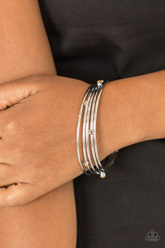 Paparazzi Delicate Decadence - Brown - Bracelet
Three shiny silver and two topaz rhinestone encrusted bangles stack across the wrist for a refined look.
