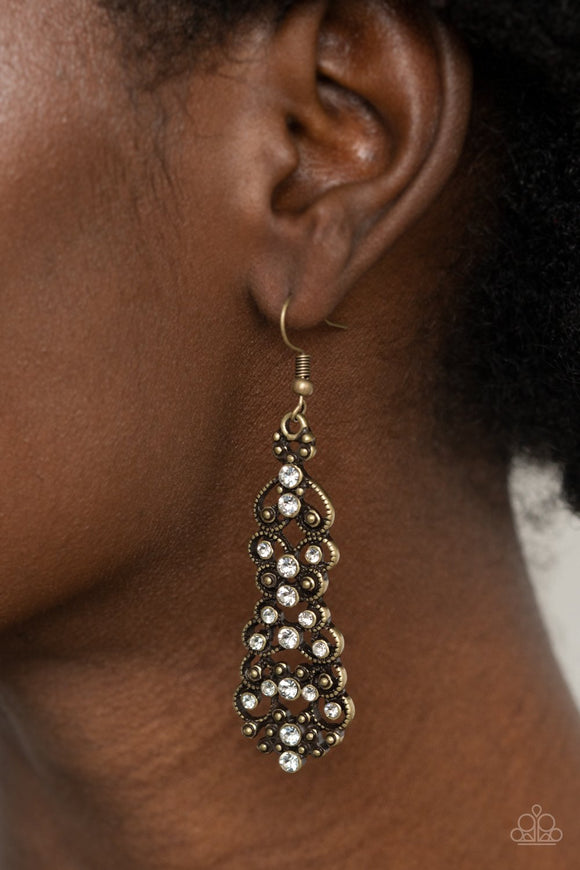 Paparazzi Diva Decorum - Brass - Earrings
Sporadically dotted in glassy white rhinestones, studded brass filigree delicately whirls into a stacked lure for an elegant display. Earring attaches to a standard fishhook fitting.
