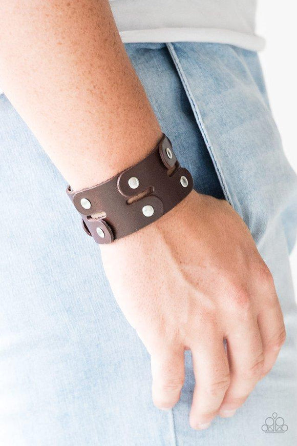 Paparazzi Downright Desperado - Brown - Bracelet
Pieces of shiny brown leather are studded together to create an edgy urban look around the wrist. Features an adjustable snap closure. 
All jewelry is Lead & Nickel Free!