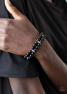 Paparazzi Downtown Debut - Black - Bracelet
Held in place with white rhinestone encrusted silver fittings, pairs of shiny black beads are threaded along stretchy bands around the wrist.
