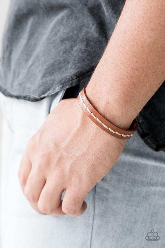 Paparazzi First Class Traveler - Brown - Bracelet
Earthy cording is stitched across the front of a skinny brown leather band for a rugged urban look. Features an adjustable snap closure. 

